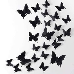 a bunch of black butterflies flying in the air