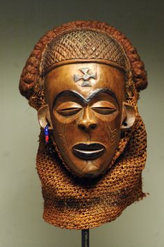 an african mask is displayed on a stand