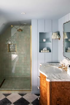 a bathroom with a sink, mirror and shower in it's corner area next to a tiled floor