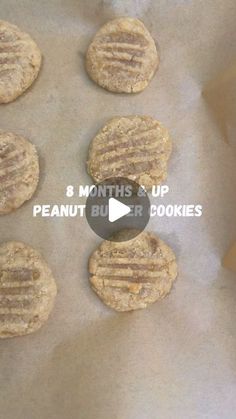 eight peanut butter cookies sitting on top of a piece of parchment paper with the words 8 months up