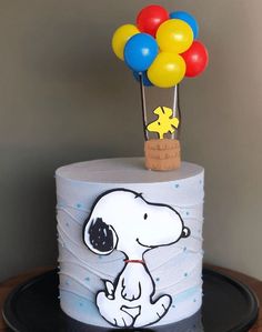 a birthday cake with a snoopy balloon on top