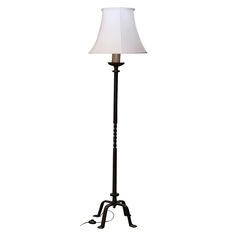 a floor lamp with a white shade on the base and a black metal pole holding a light bulb