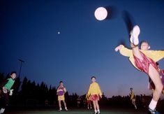 a group of young men playing a game of frisbee on top of a field