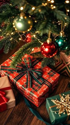 presents under the christmas tree are wrapped in red, green and gold paper with bows