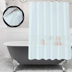 a bath tub sitting under a bathroom mirror next to a shower curtain with pictures on it