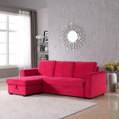 a living room with a red sectional couch and white rugs on the hardwood floor