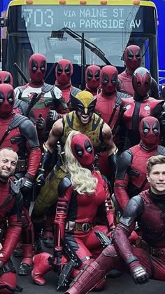 a group of deadpools posing for a photo in front of a bus