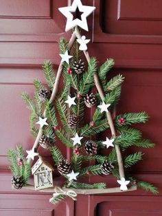 a christmas tree made out of branches with white stars and pine cones hanging from it