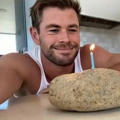 a man with a candle in his hand next to a baked potato