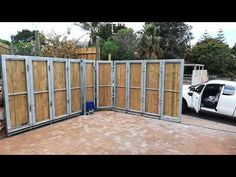 a white truck parked in front of a wooden fence with doors open on the side