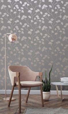 a chair and lamp in front of a wallpapered room with flowers on it