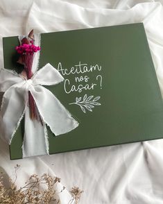 a green box with a white ribbon tied around it