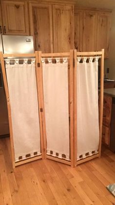 a room divider in the middle of a kitchen with wood flooring and cabinets