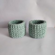 two knitted baskets sitting next to each other