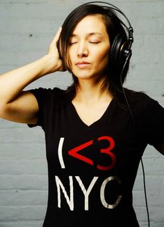 a woman listening to headphones while wearing a t - shirt that says 3 nyc