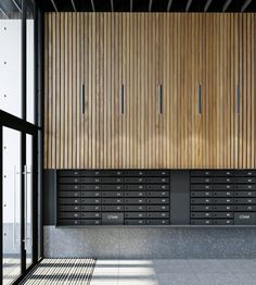 an empty room with wooden paneling on the wall and doors leading to another area