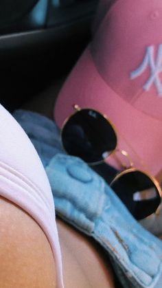 there is a baseball cap and sunglasses on the back of a woman's head