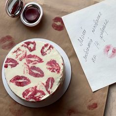 a piece of paper that has lipstick on it next to a cake with writing on it