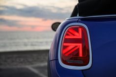 the back end of a blue car with an union jack on it's tail light