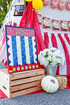 there is a carnival display with balloons and flowers on the table, along with other decorations