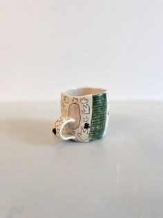 a ceramic cup with an animal design on the outside and inside, sitting on a white surface