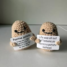 two little crocheted stuffed animals holding signs with words written on them that read positive potato