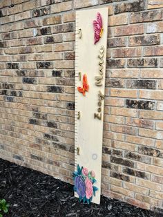 a growth chart with butterflies on it in front of a brick wall that says love