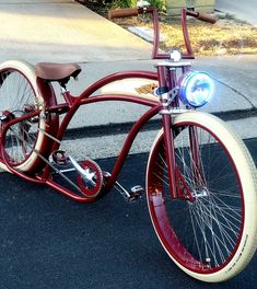 an old fashioned bicycle is parked on the side of the road with its lights on