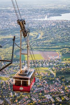 an aerial view of a cable car in the sky over a city and lake,