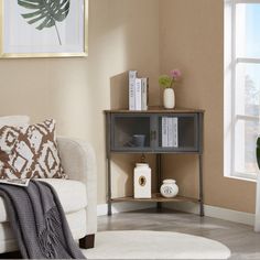 a living room with a couch, table and potted plant on the sideboard