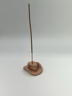 a small hat on top of a rock with a stick sticking out of it's side