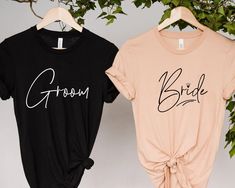 two t - shirts with the words bride and groom on them hanging from a tree