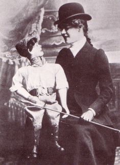 an old black and white photo of two women standing next to each other, one holding a cane