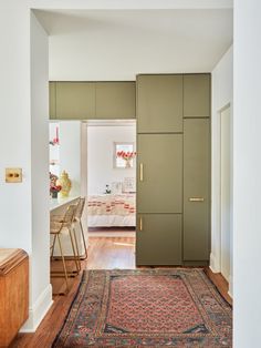 an open door leading to a bedroom with a rug on the floor