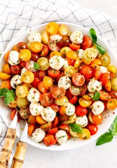 a white bowl filled with tomatoes and mozzarella cheese