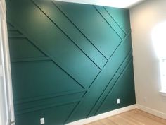 an empty room with green painted walls and wood floors