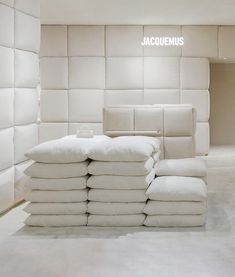 a stack of white pillows sitting on top of each other in front of a wall