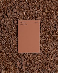 a piece of brown paper sitting on top of gravel next to a pile of rocks