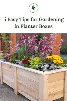 a wooden planter box filled with flowers and plants