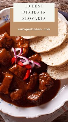 a white plate topped with meat covered in gravy next to pita bread