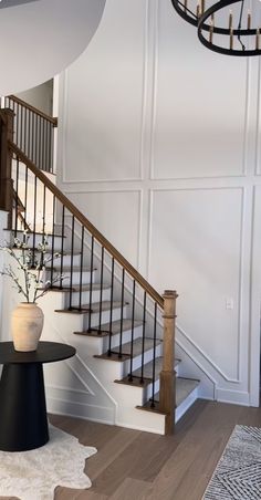 there is a vase with flowers in it on the table next to the stair case