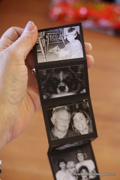 a person holding an open photo book with pictures on the pages and two dogs in it