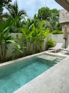 an outdoor swimming pool with lounge chairs and umbrella