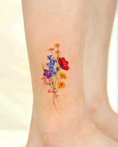 a colorful flower tattoo on the ankle