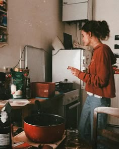 a black and white photo of a woman in the kitchen