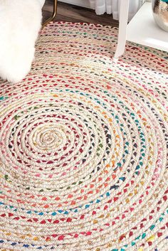 a multicolored rug on the floor with a white chair in front of it