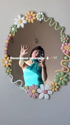 a woman taking a selfie in front of a mirror with flowers on the wall