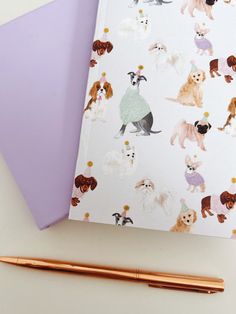 two notebooks with dogs on them next to a pen