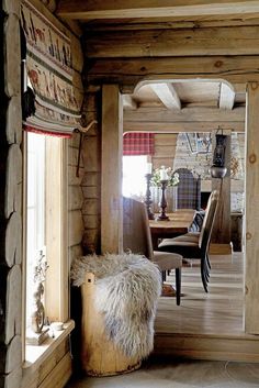 the interior of a rustic log cabin with wood floors and walls is decorated in natural materials