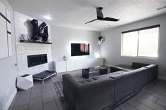 a living room with two couches and a flat screen tv mounted on the wall